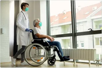 A wheelchair being fitted and adjusted for a patient at home